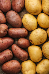 Poster - top view of organic raw potatoes on brown rustic sackcloth