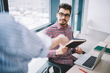 Wall Mural - handsome man office worker in trendy eyeglasses for vision correction sitting at desktop with new ne