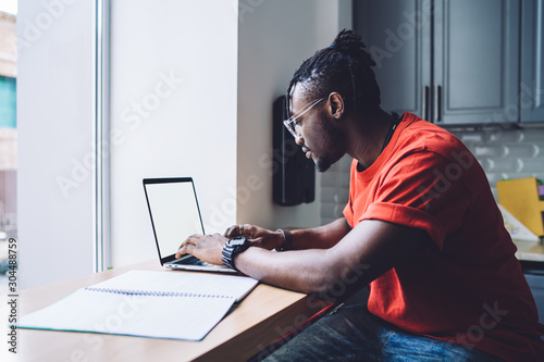 Smart black man working on laptop