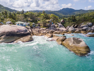 Wall Mural - Aerial view of turquoise waves beating on stones. Thailand