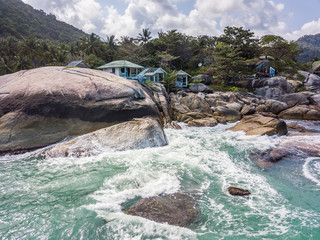 Wall Mural - Aerial view of turquoise waves beating on stones. Thailand