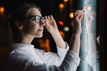 Wall Mural - digital monitor with public transport subway map. female standing at big display with advanced innov