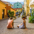 A boy and girl sitting on the street, having rest in Imperia, old Italian city