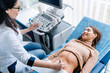 © InsideCreativeHouse - Doctor using ultrasound and screening woman's stomach