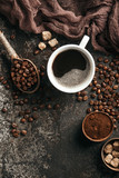 Fototapeta Boho - Coffee board with coffee beans on dark textured background.