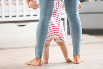 Canvas Print - Mother teaching her little baby to walk at home