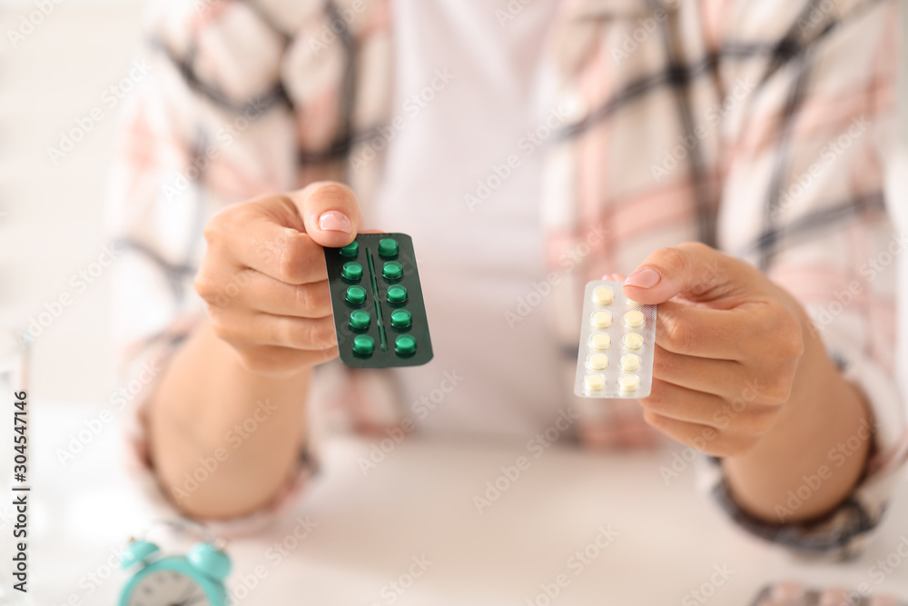 Young woman with pills at home, closeup