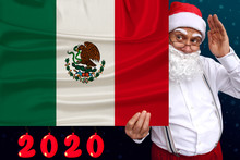 Santa Claus With A Beard Holds A Beautiful Colored National Flag Of The State Of Mexico On Fabric, Concept Of Tourism, New Year And Christmas, Economic And Political Prospects