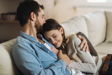 Wall Mural - Young affectionate couple enjoying together while man is kissing his girlfriend in head