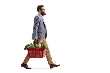 Canvas Print - Bearded man walking and carrying a shopping basket with food