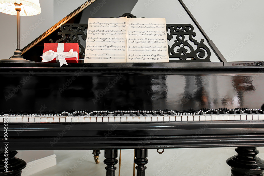 Grand piano with Christmas gift in room