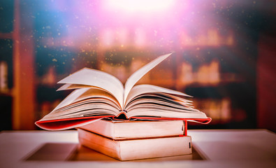 Poster - Stack of books in the library and blur bookshelf background
