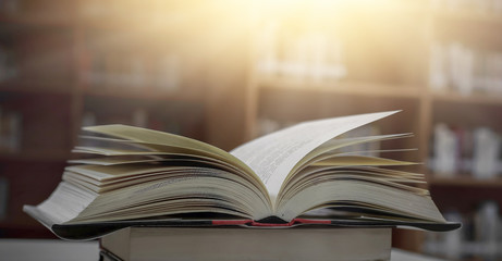 Poster - Stack of books in the library and blur bookshelf background