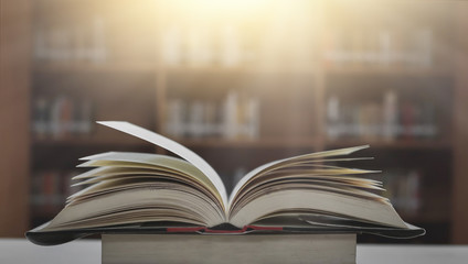 Poster - Stack of books in the library and blur bookshelf background