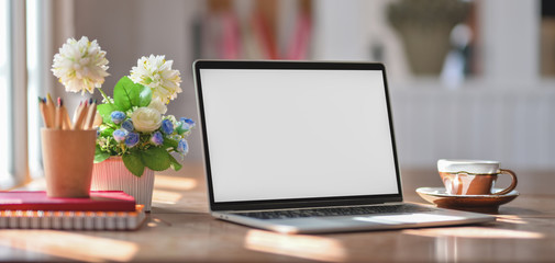 Close-up view of comfortable workplace with mock up laptop computer and office supplies on wooden table