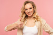 © LIGHTFIELD STUDIOS - Smiling woman with dental braces showing thumb up gesture isolated on pink