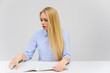 © Вячеслав Чичаев - Concept cute model student secretary works sitting at a table. Close-up portrait of a beautiful blonde girl with excellent makeup with long smooth hair on a white background in a blue shirt.