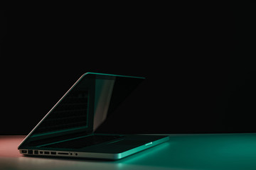 Aufkleber - Beautiful silver laptop in the color light on a table and night background.