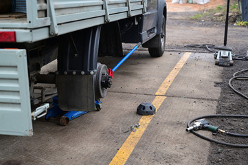 Concept Photography with a tire fitting. The worker serves the car, changing tires on the wheel. Removes or puts on a wheel, unscrews the nuts using a special tool.