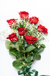 Beautiful bouquet of red roses and baby's breath white flowers isolated on a white background, top view.