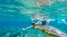 A Man In A Diving Mask And Fins Diving Along A Turtle, Next To The Shore Of Gili Air, Lombok Indonesia. Beautiful And Crystal Clear Water. Peaceful Coexistence Of Human And Animal. Dream Coming True.