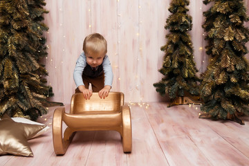 Wall Mural - a boy near the Christmas trees on a sled, Christmas lights, rejoices and smiles, plays. holiday and vacation