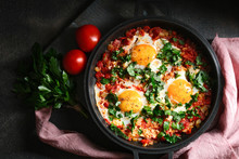Traditional  Shakshuka With Eggs, Tomato, And Parsley In A Iron Pan On A Dark Background. Top View.