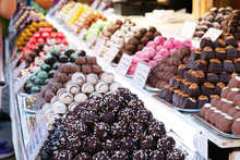 Assortment Of Delicious Chocolate Candies For Sale On Counter Of Shop, Market, Cafe. Variety Of Marzipan Candy Balls On The Store Shelves.