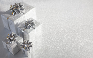 silver holiday gifts on glitter background