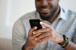 © fizkes - Close up of smiling biracial man using modern smartphone gadget