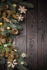 fir branches with Christmas decor on old dark wooden background