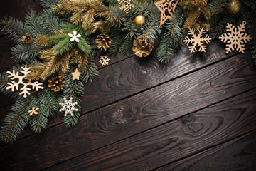 fir branches with christmas decor on old dark wooden background