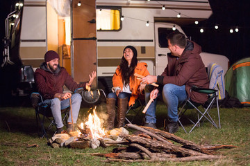 girl laughing hard after her friends told a joke around camp fire