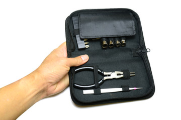 a hand of adult holding the black bag of multi purpose tool kit on white background