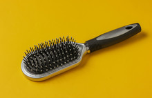 Stylish Hairbrush On Yellow Background. Women's Hair Care Accessories.