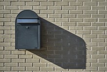 Wall Mounted Mailbox On A Brick Wall Captured Under The Sunlight