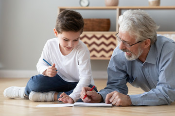 Wall Mural - Grandfather playing with little grandson, drawing colored pencils