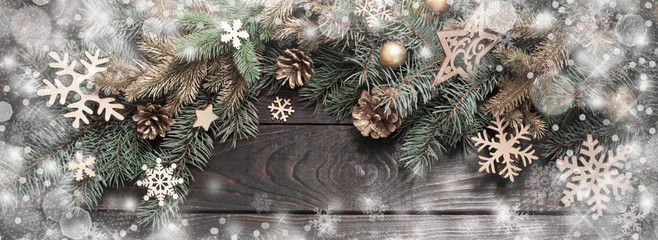 fir branches with christmas decor on old dark wooden background