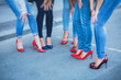Row line of a legs on high heels in jeans pants during bachelorette party or a birthday, a group of bridesmaids having fun