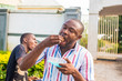 young black people eating voraciously, enjoying food, eating with their hands in the street