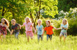 © Andrey - A group of happy children of boys and girls run in the Park on the grass on a Sunny summer day . The concept of ethnic friendship, peace, kindness, childhood