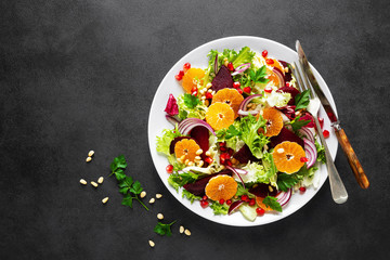 Christmas salad with boiled beet, red onion, tangerines, pomegranate, parsley, pine nuts and lettuce leaves