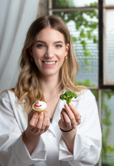 doctor, health care professional, dietitian offering two choices of cup cake or broccoli. Concept of healthy decisions. 