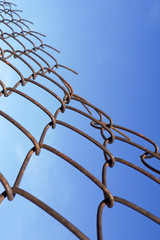 metal rusty fence from old wire against the sky