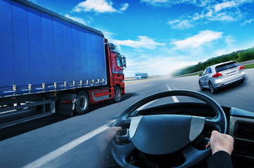 Canvas Print - Abstract background with a truck, truck steering wheel and a family car against sky