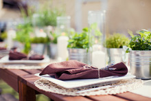 Table Setting In Rustic Style With Herbs, Apples And Brown Napkins