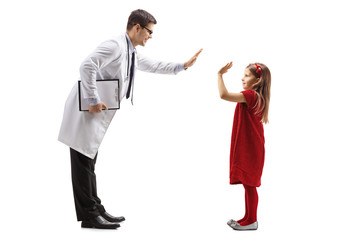 Wall Mural - Male doctor giving a high-five to a little girl