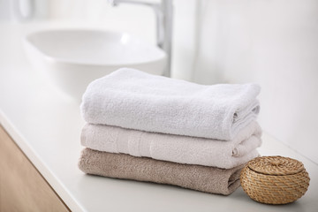 Stack of fresh towels on countertop in bathroom