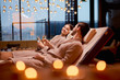 © alfa27 - Young caucasian couple take care of body together lying in spa salon and drinking champagne, wearing bathrobe