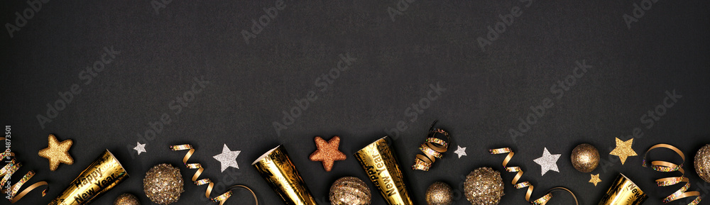 New Years Eve border banner of glittery gold stars, streamers, decorations and noisemakers. Above view over a black background. - obrazy, fototapety, plakaty 